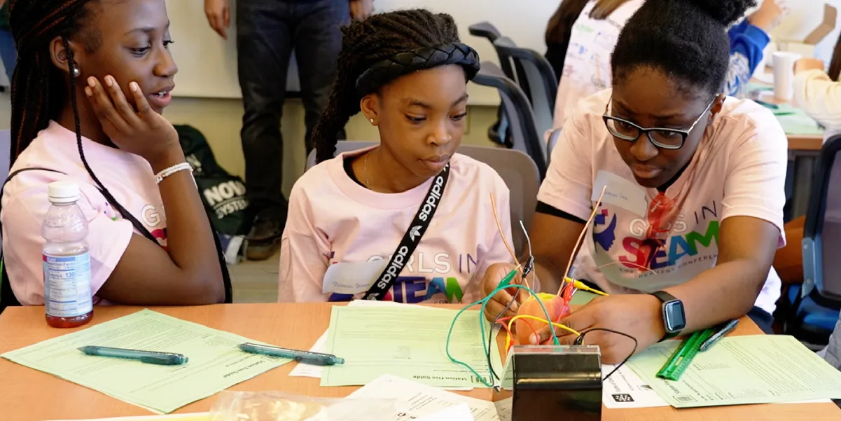 Three students working on a STEAM activity