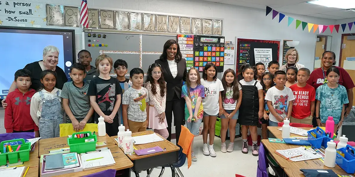 Superintendent LaTanya D. McDade poses for a photo with students and staff in a classroom at Sudley Elementary School