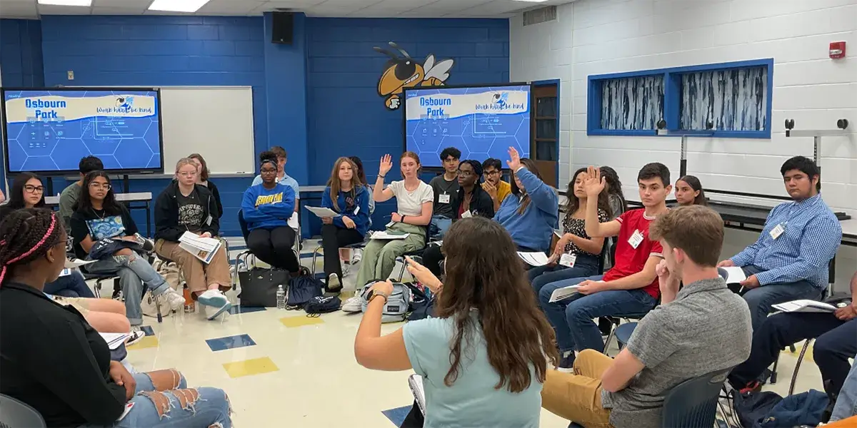 Large group of students seated in a circle in a classroom at Osbourn Park High School