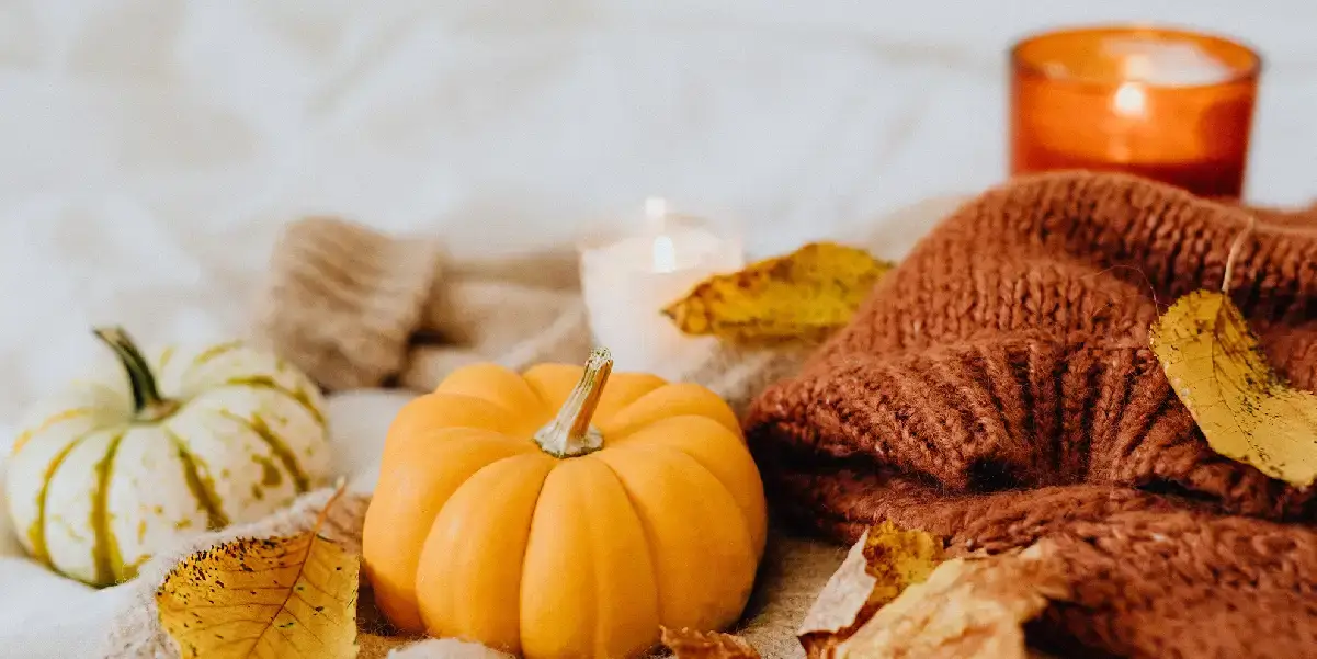 Thanksgiving decorations with pumpkins, candles, and leaves