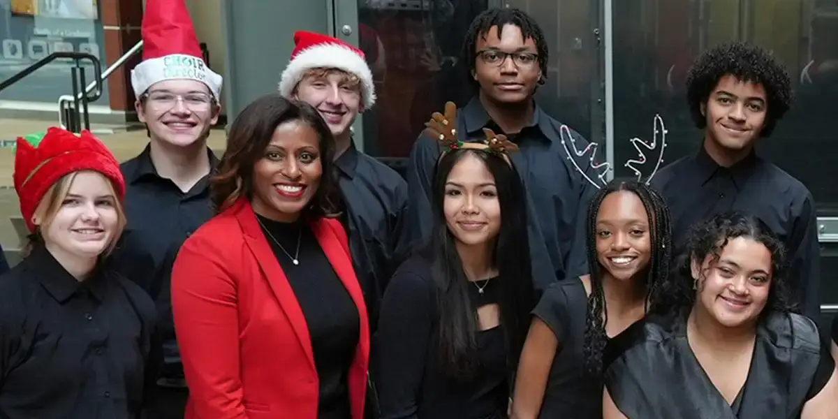 Superintendent McDade poses for a phone with members of the Patriot High School choir following their holiday performance at the Kelly Leadership Center