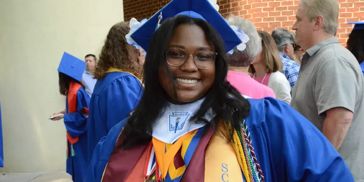 Prince William County Public Schools graduate dressed in a cap and gown on her graduation day