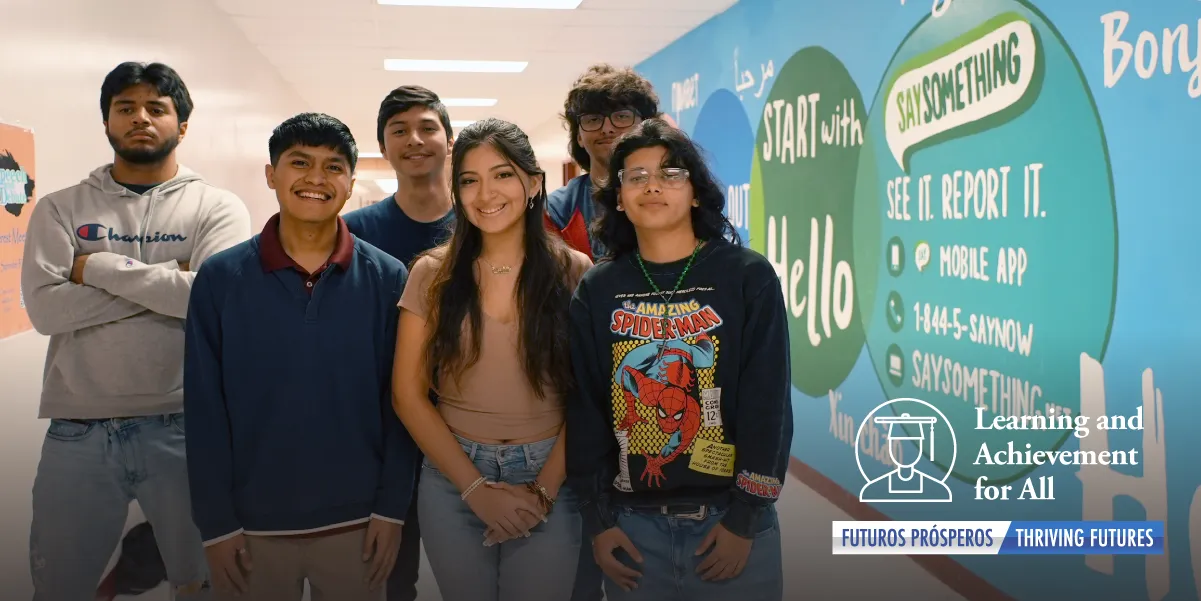 students standing in hall in front of mural