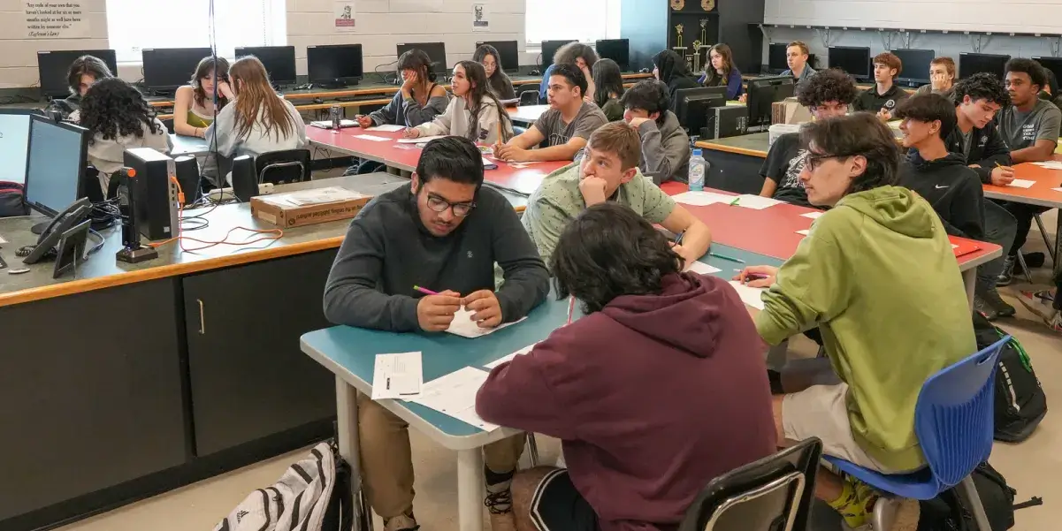 High school students actively engaged in class in a computer lab