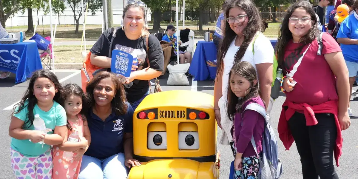 Superintendent Dr. McDade posing for a photo with a family at the 2024 PWCS Community Event at Unity Reed High School