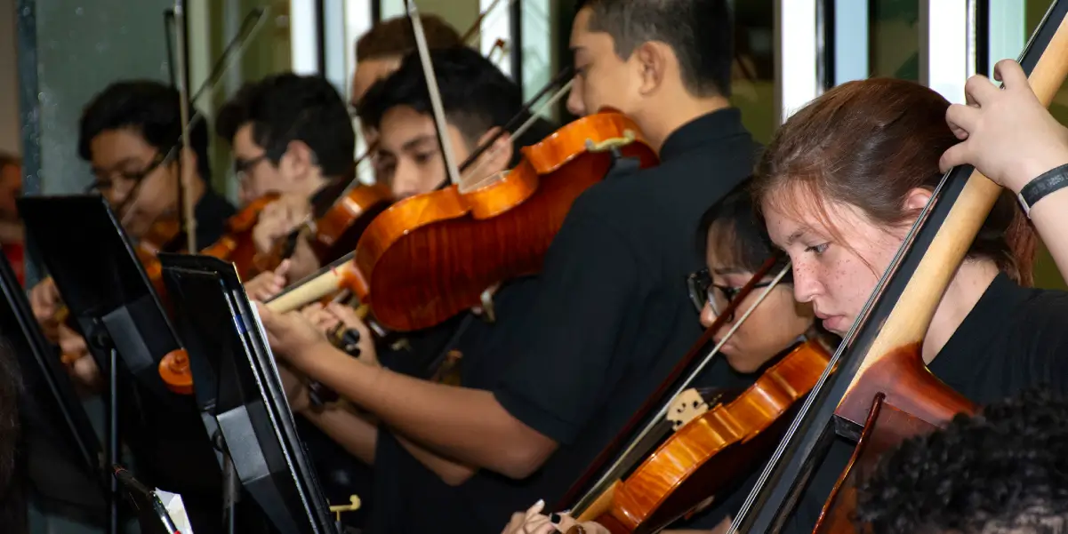 Students playing instruments during an orchestra performance