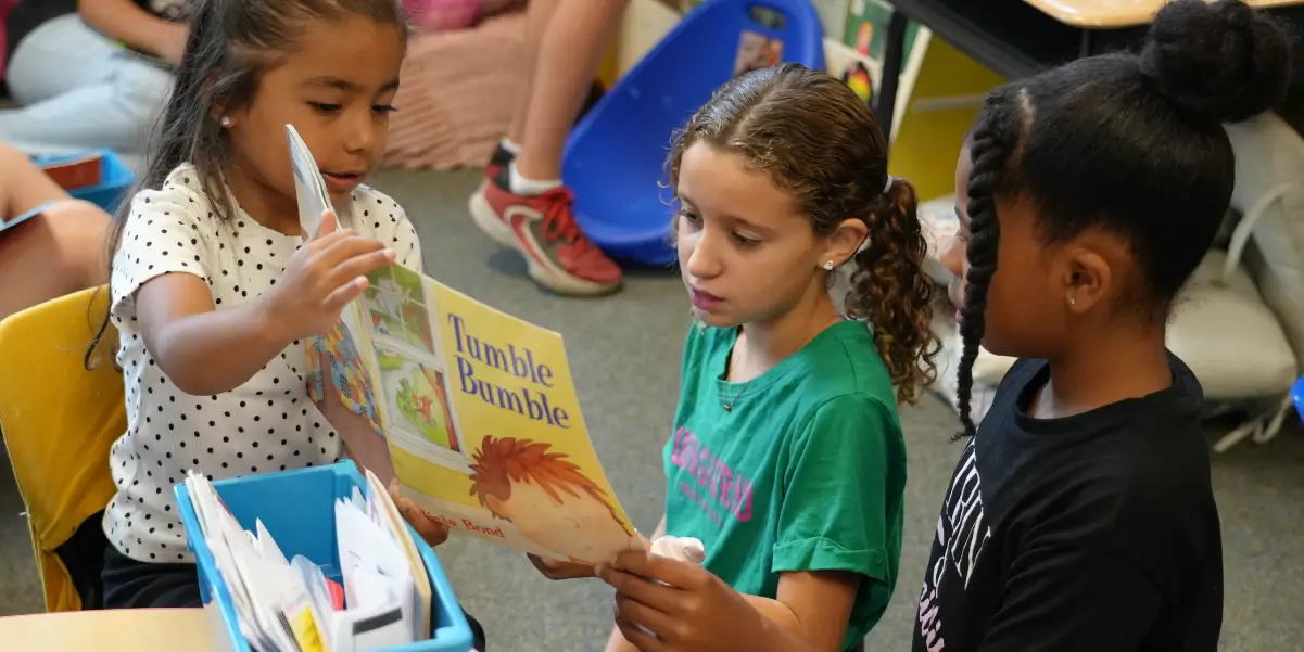 Elementary school students reading a book