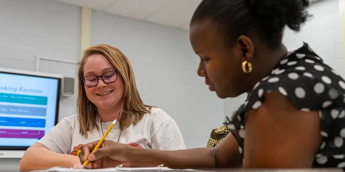 Staff member and parent sitting next to each other during a family engagement event at Bennett Elementary School