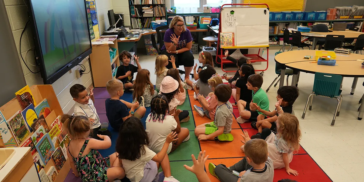 Teacher speaking to students sitting in a classroom