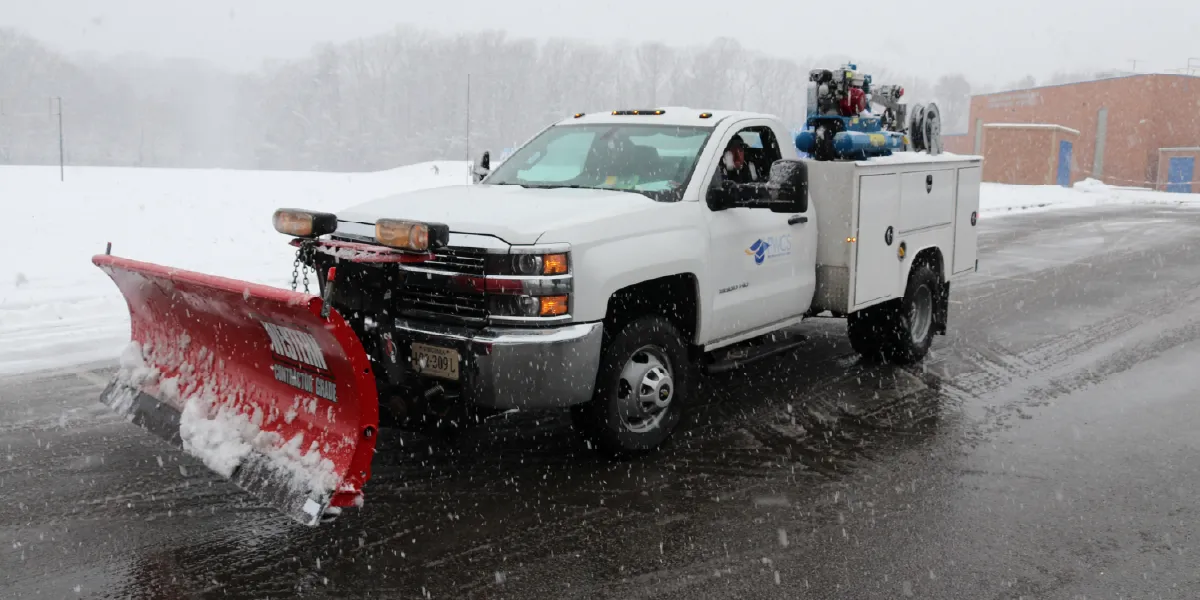 PWCS facilities staff plowing a parking lot and spreading salt during a snow storm