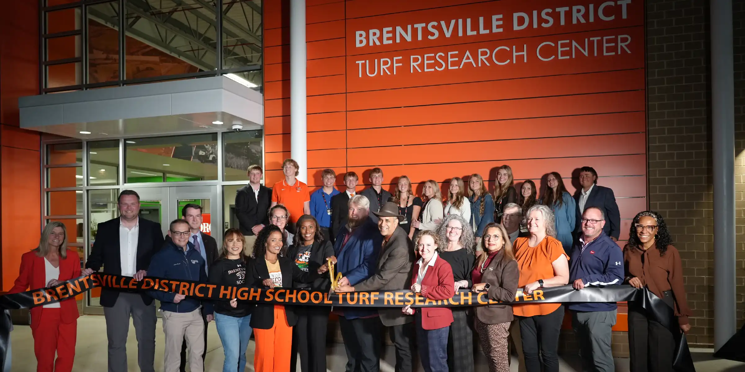 Group photo at the entrance of the Brentsville District Turf Research Center during a ribbon-cutting ceremony.