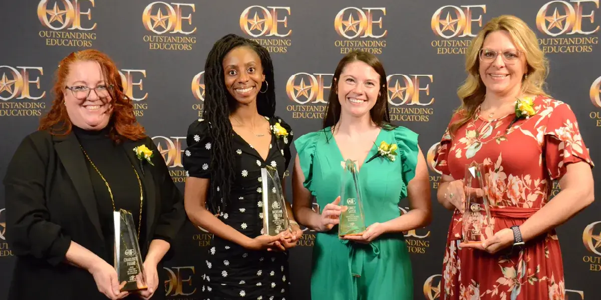 Four winners of the Outstanding Educators Awards for novice teacher of the year and teacher of the year holding their awards