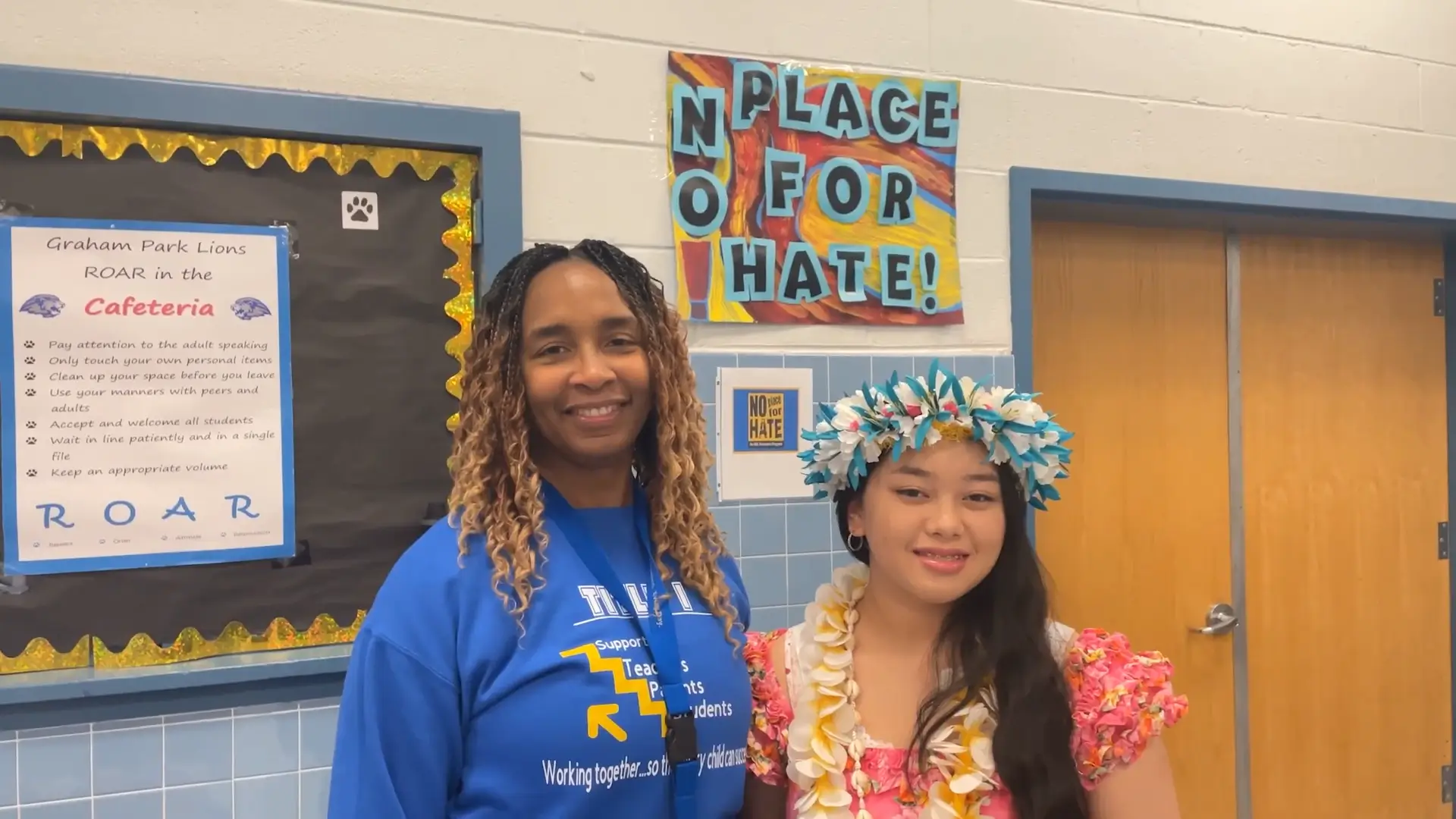 FACES staff member and student posing together in school hallway