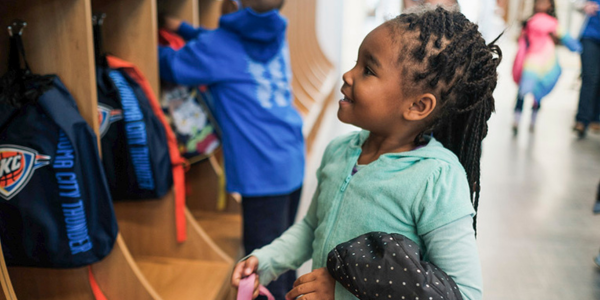 Child placing a bookbag