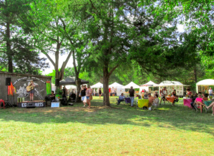 An outdoor vendor fair setup on a grass field An outdoor vendor fair setup on a grass field