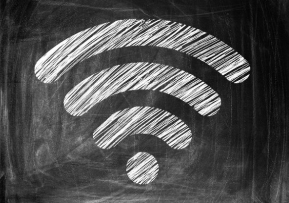 The symbol denoting wireless access drawn in white chalk on a blackboard
