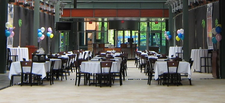 the KLC atrium decorated for a banquet/dinner event with balloons and tables covered in tablecloths