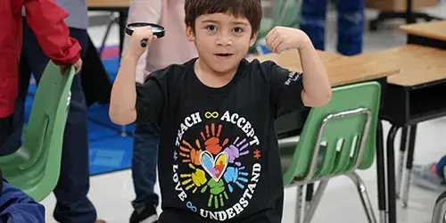 Elementary school student wearing Autism acceptance T-shirt
