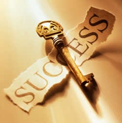 The word Success on a piece of paper and a golden colored key.