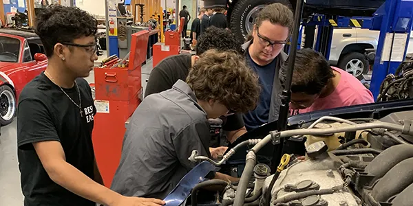Students working on a car in an automotive technology class
