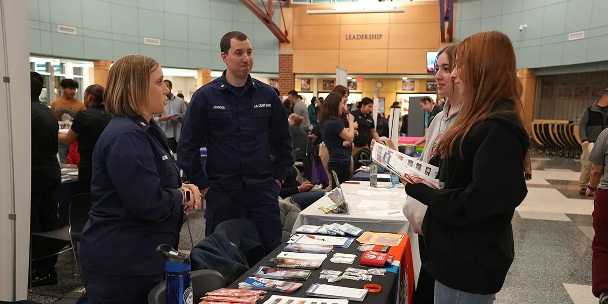 Students talking to a military recruiter at a career fair