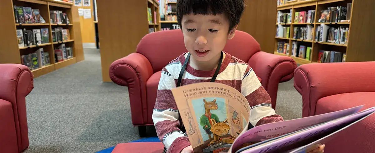 West Gate Elementary School student reading a book in the school library