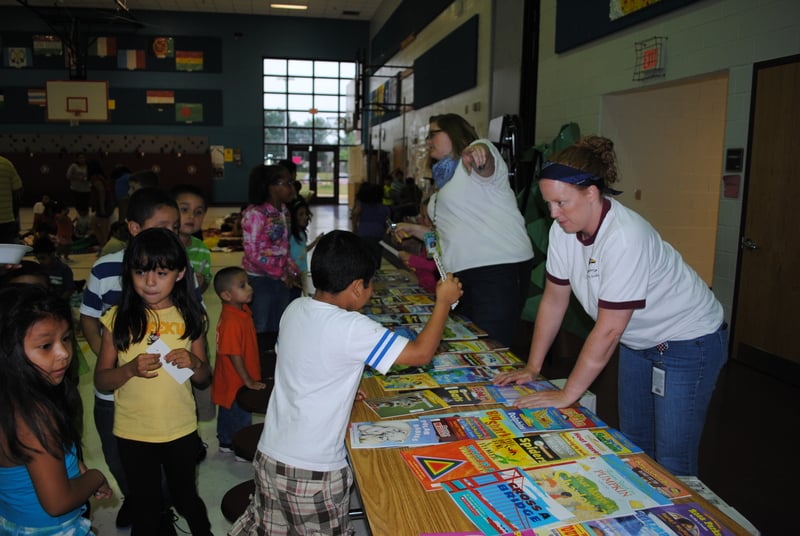 Students choosing books to take home at a family engagement school event