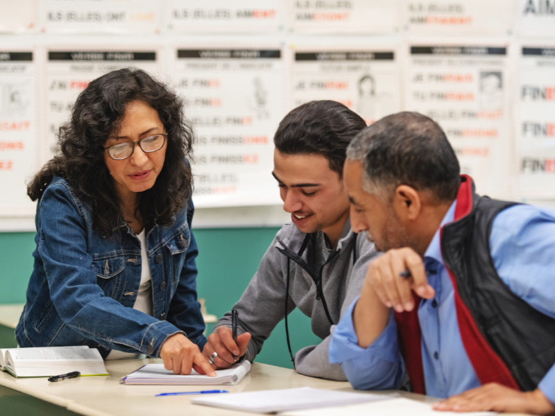 Teacher helping two adult students
