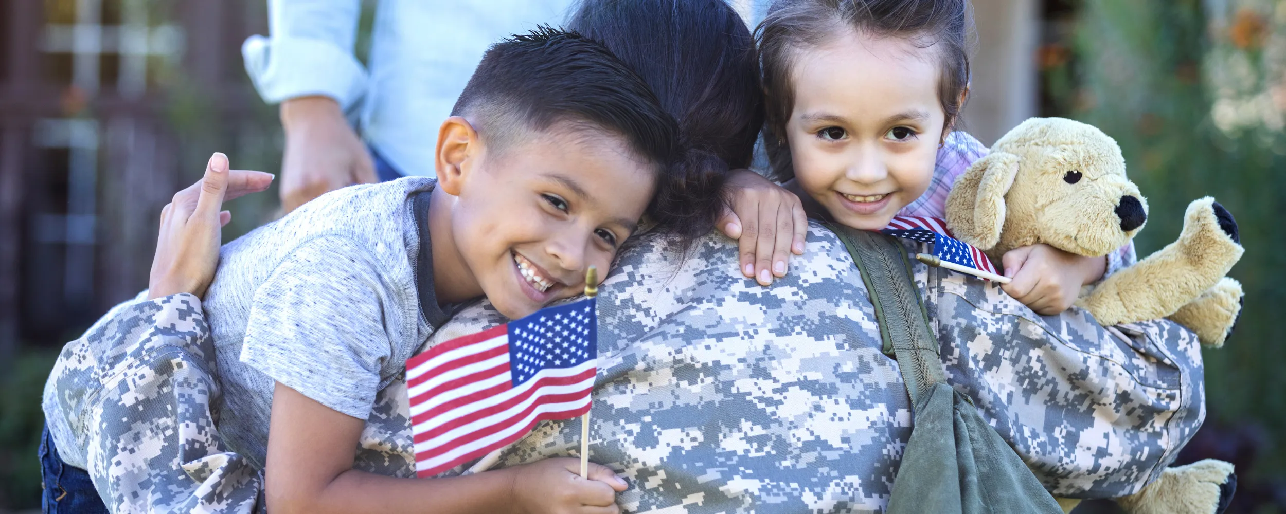military mom hugging two children
