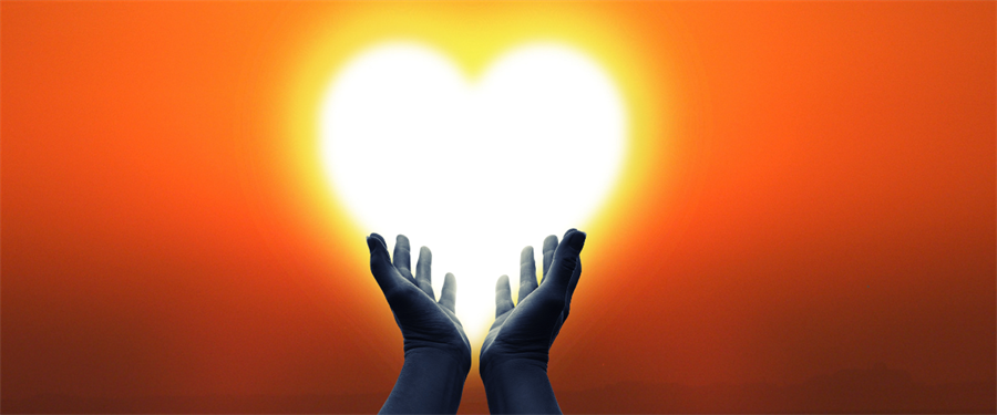 Image of hands holding up a heart with sunshine