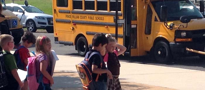 Students waiting to get on a school bus