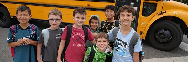 Piney Branch Elementary School students standing in front of a school bus